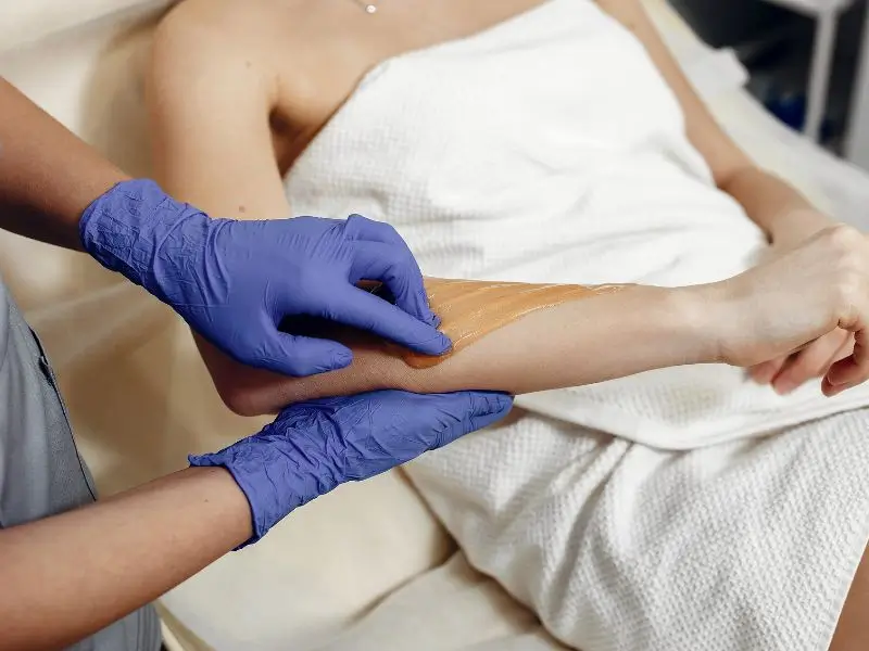 Girl is getting the best fruit wax in Fasialabad from Allure salon
